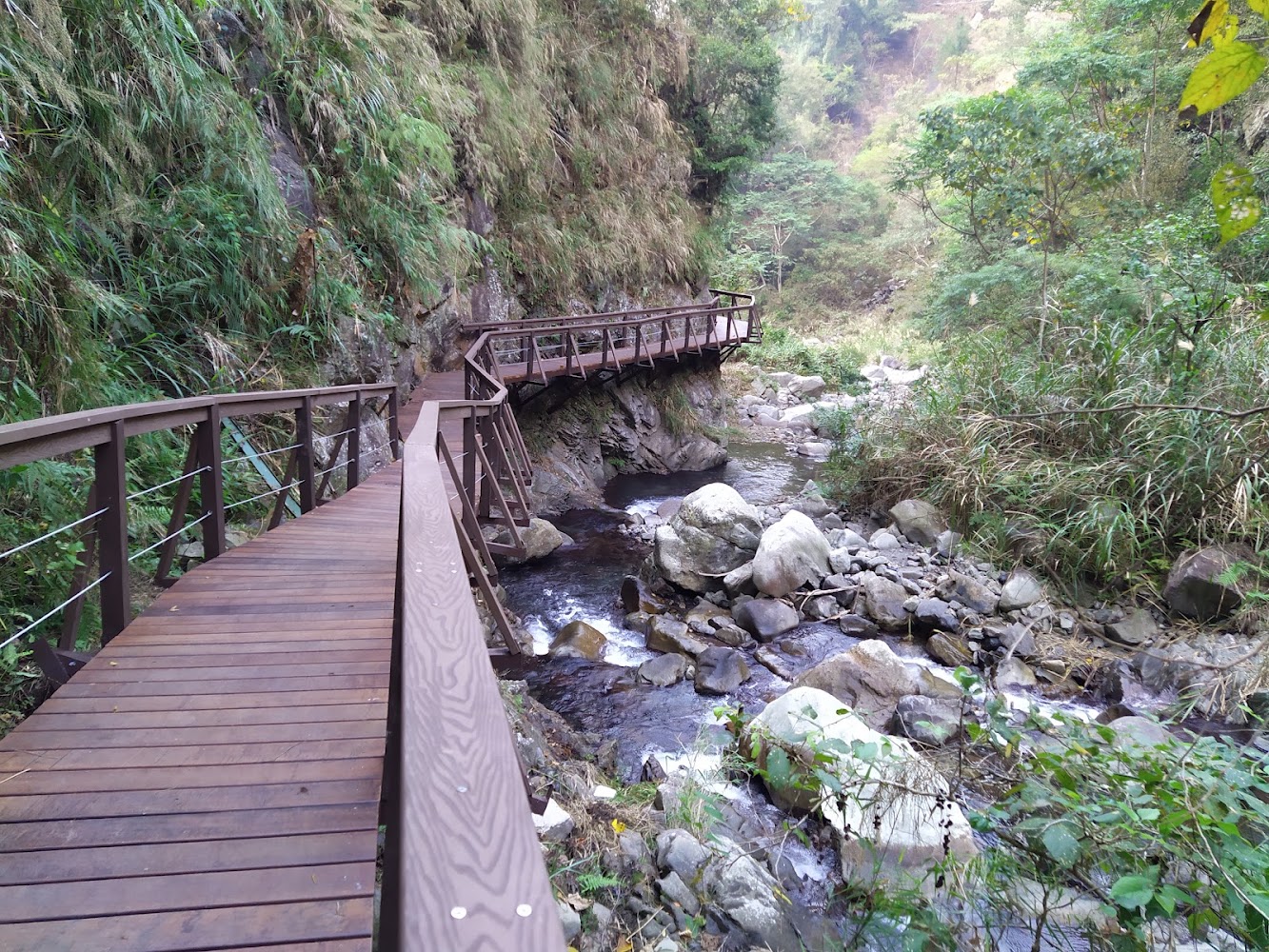 蝴蝶谷瀑布山谷溪流旁蜿蜒木棧道景觀