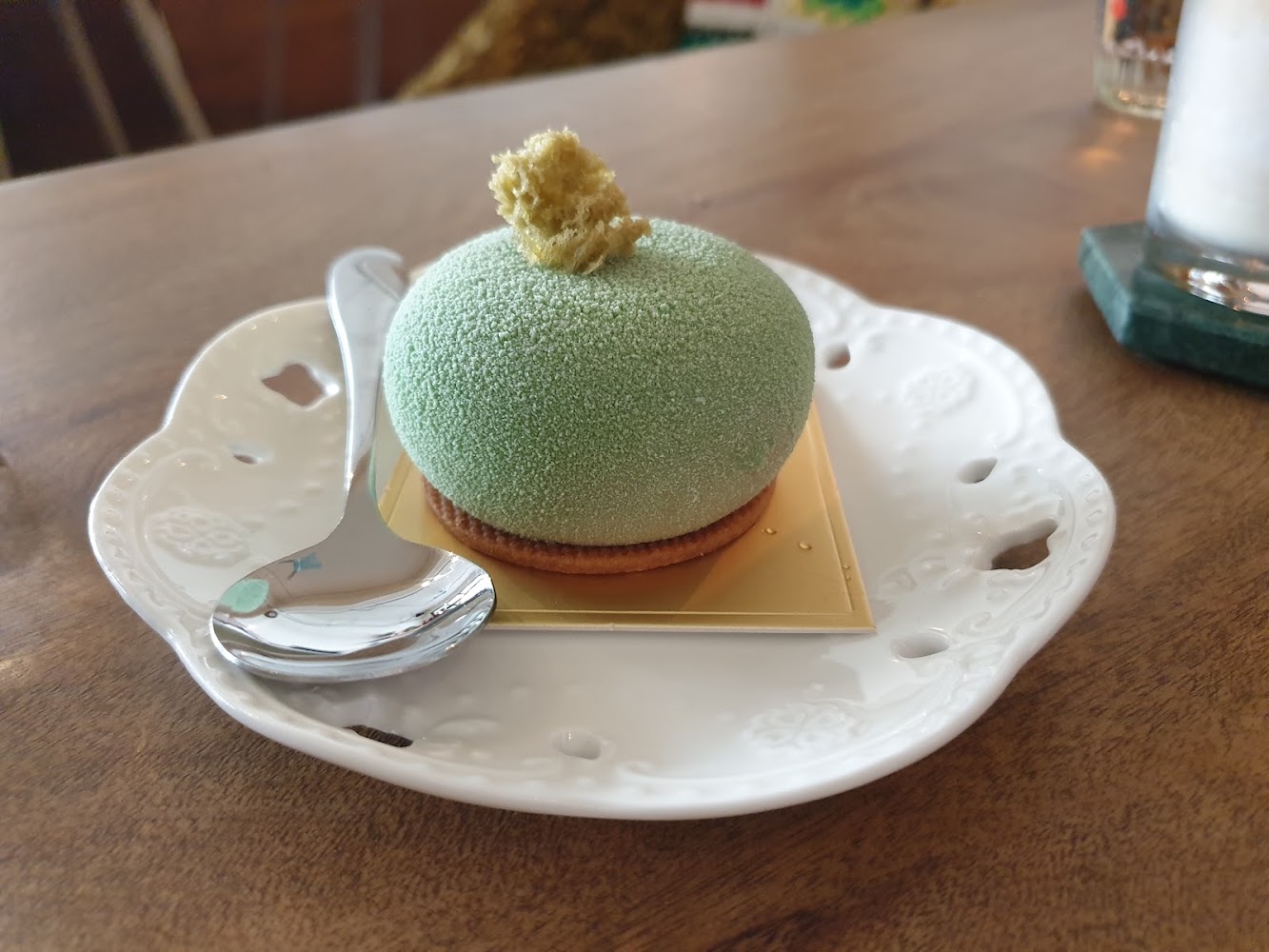 精緻綠色圓形甜點放在雕花瓷盤上