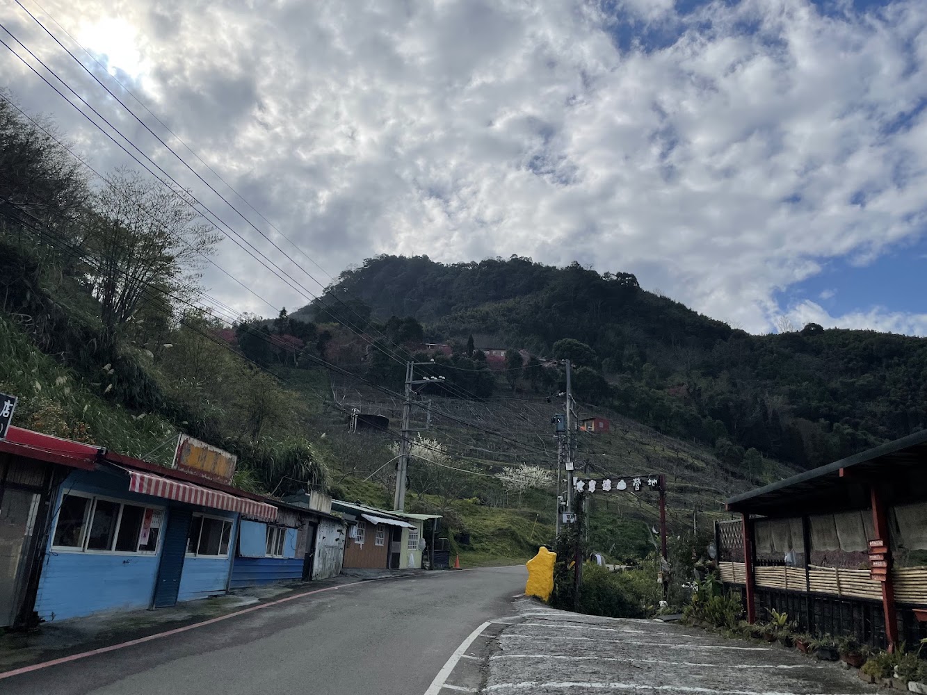 沿著道路而建的小屋店鋪與綠意山丘景色