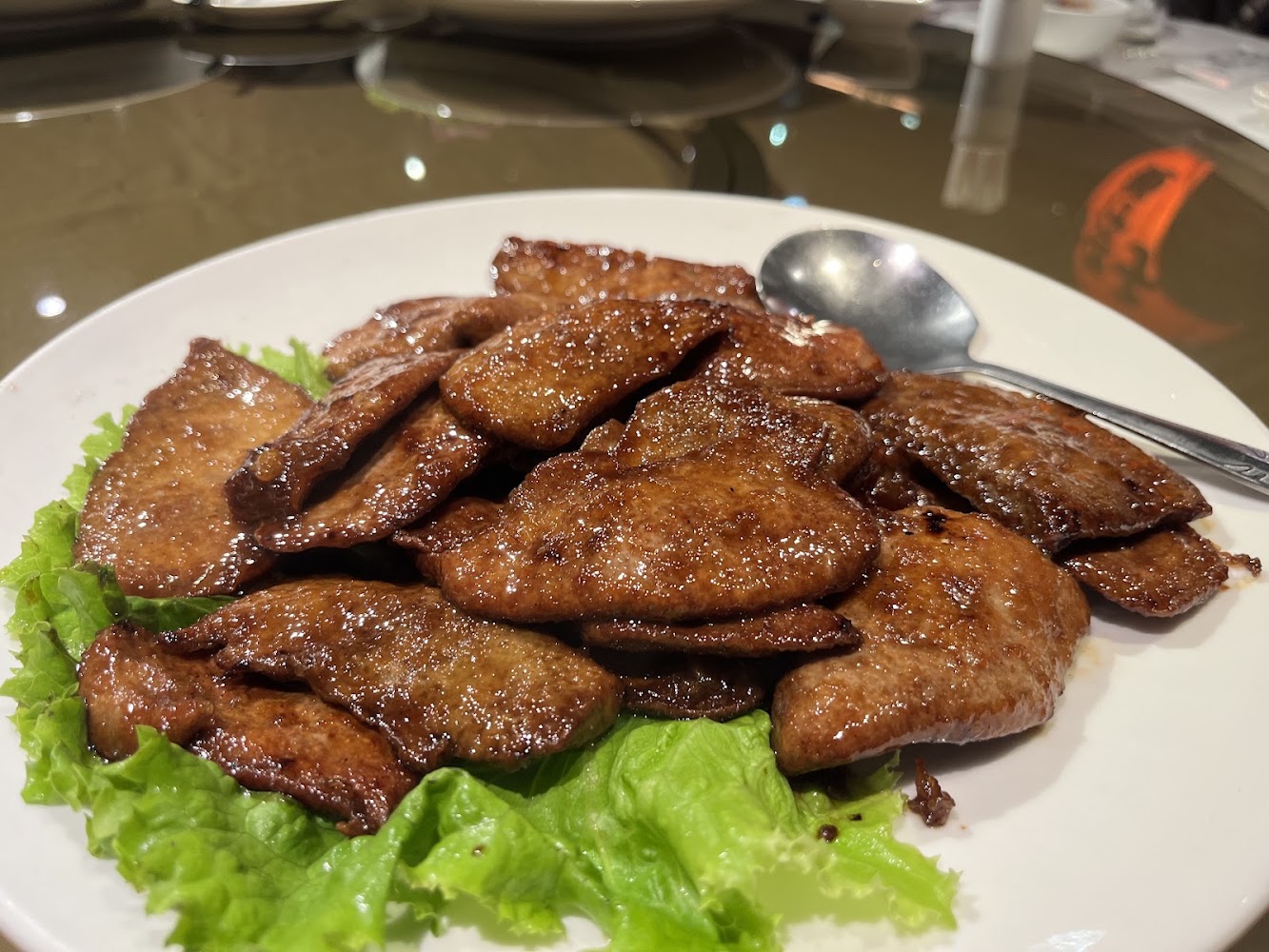 一盤煎牛肝,牛肝片呈金黃色,表面有油亮醬汁