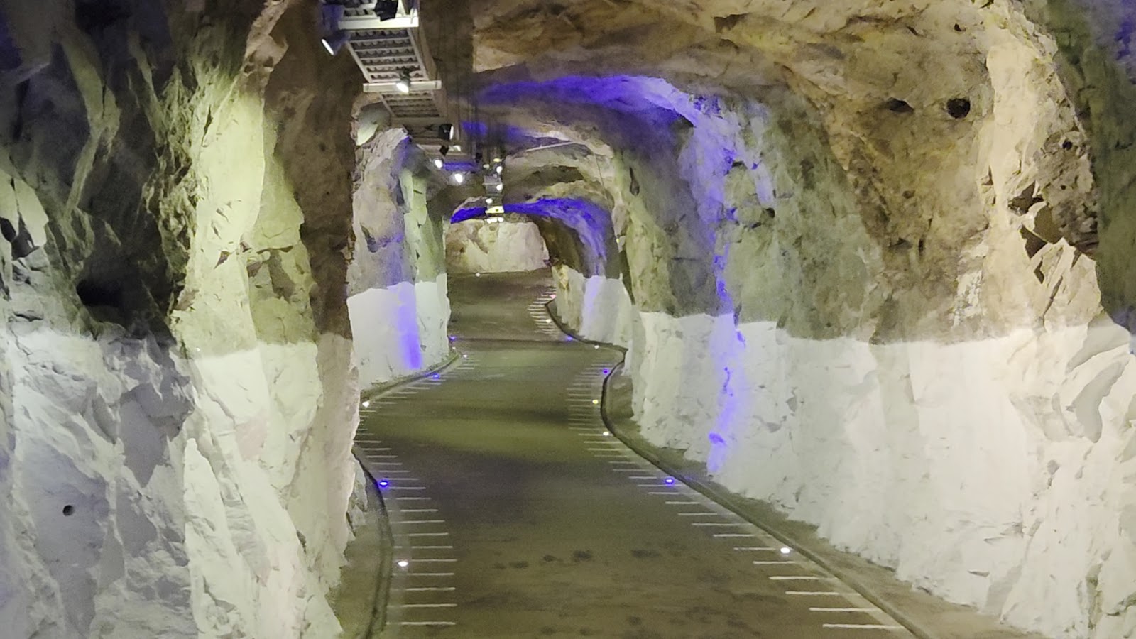 獅山砲陣地坑道內部藍紫燈光步道，岩壁鑿刻痕跡清晰可見