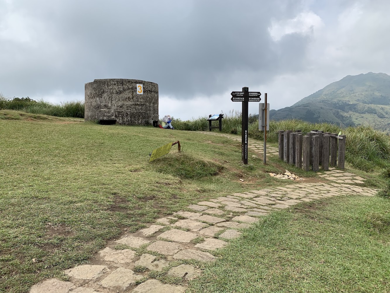 圓形混凝土建築前有石板步道與指標牌