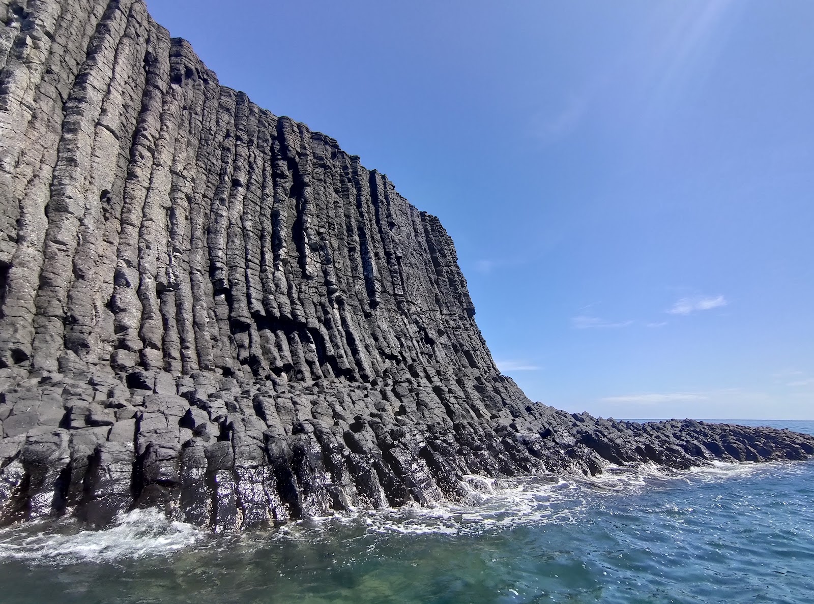 員貝嶼高聳柱狀玄武岩峭壁，岩柱緊密排列直插入海