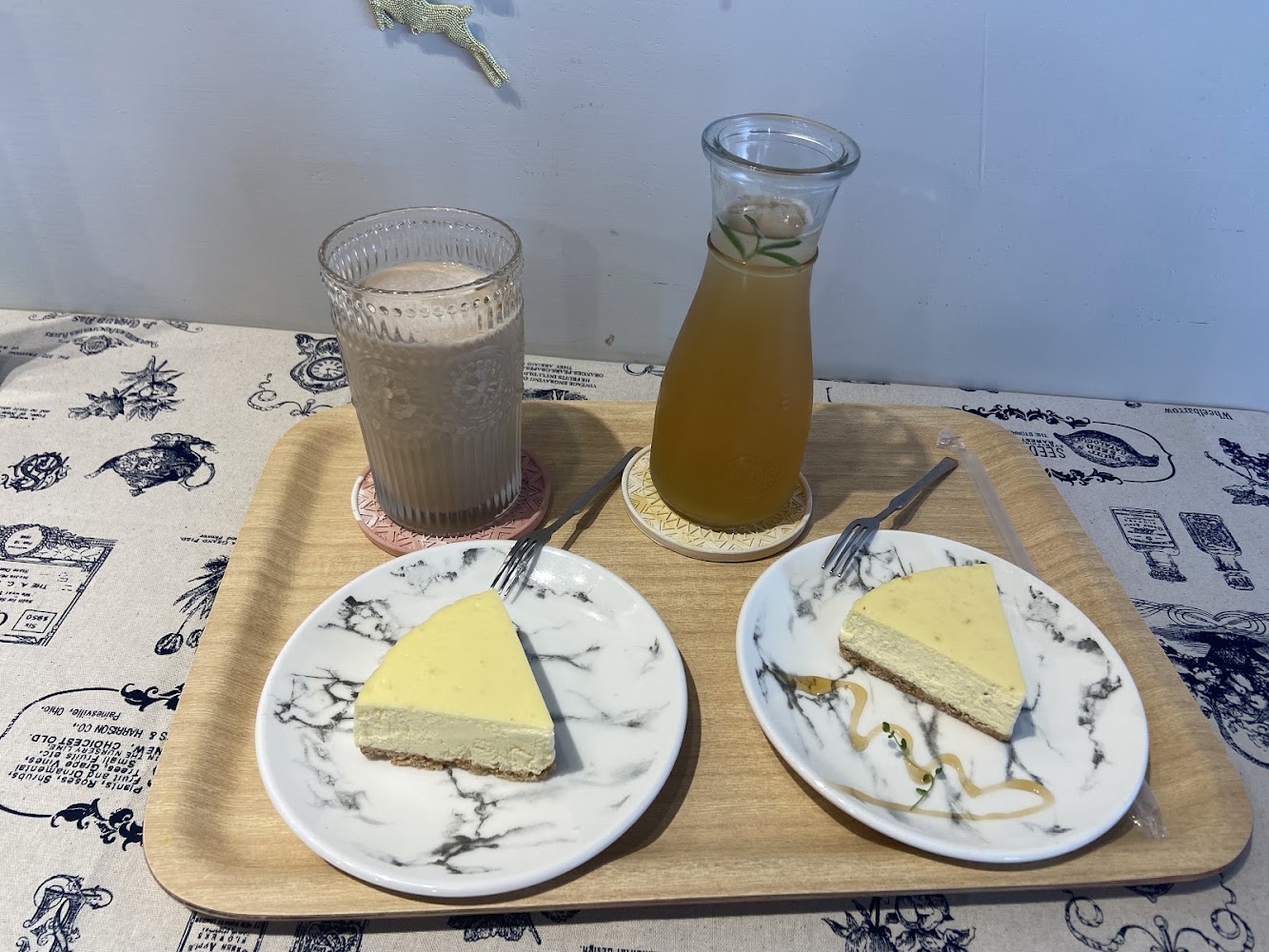 兩塊起司蛋糕與冷飲木托盤