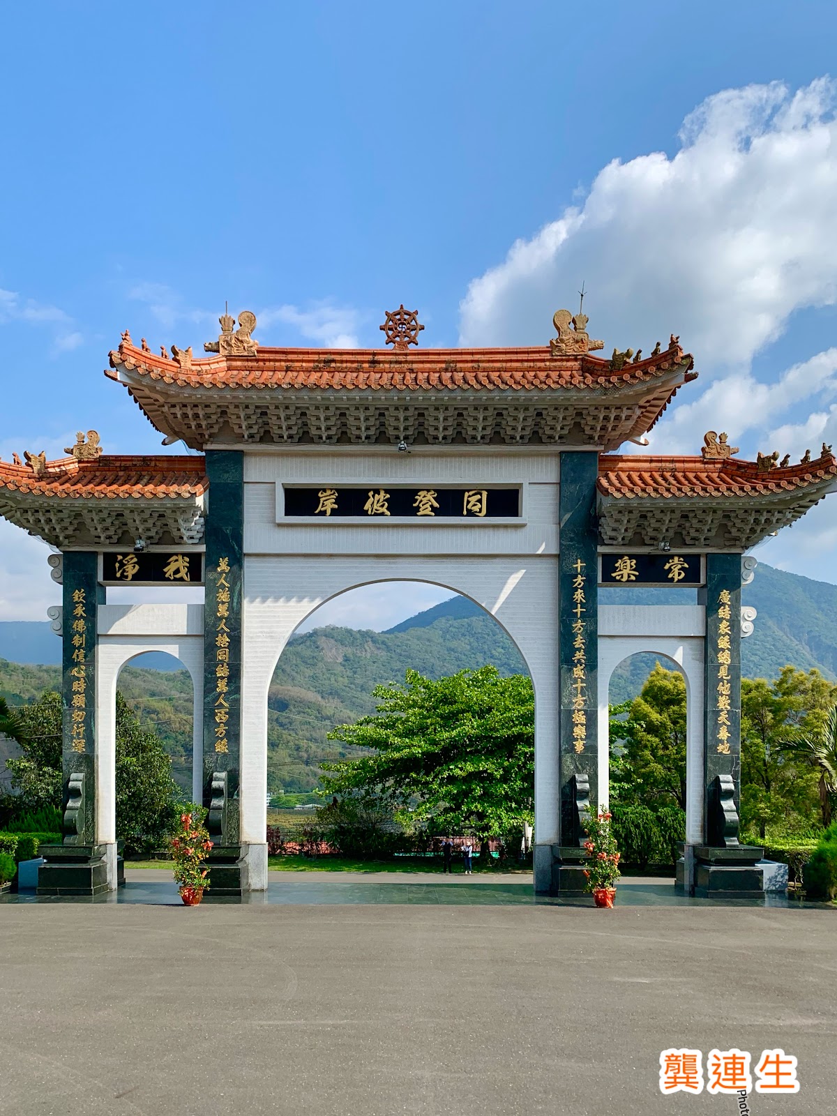 妙通寺山門牌樓，藍天白牆對比鮮明，穿過牌樓即進入清修境地