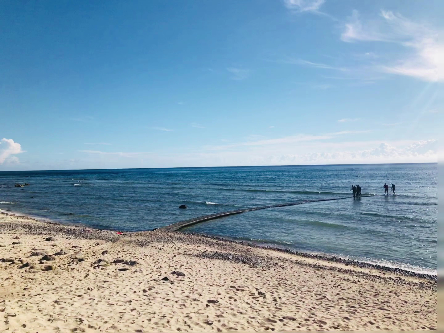 石朗海灘全景礁石平台延伸入海遊客站立礁石旁綠島