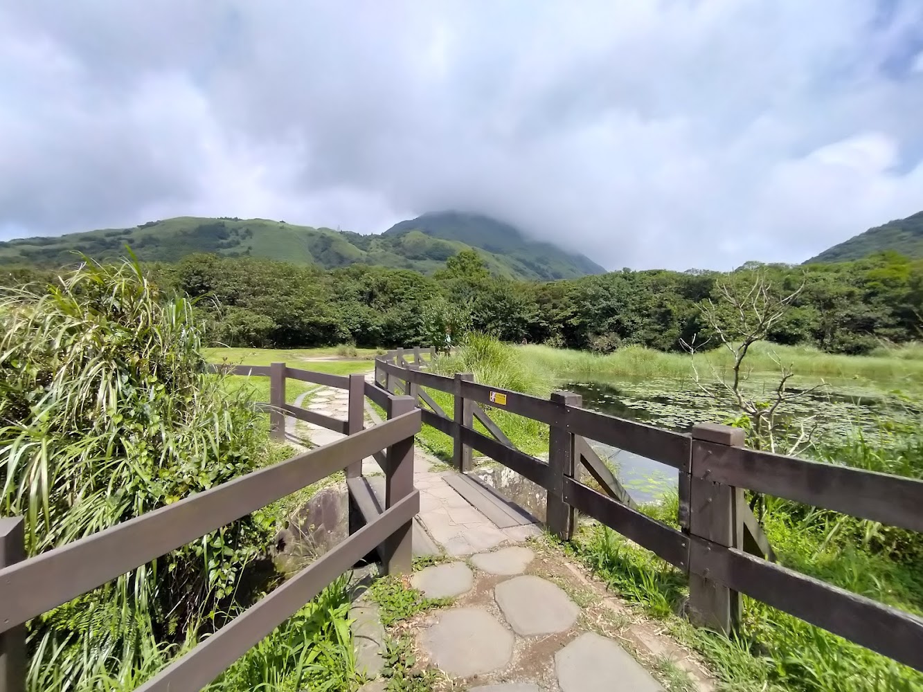 石板步道、木欄杆與山景蓮花池