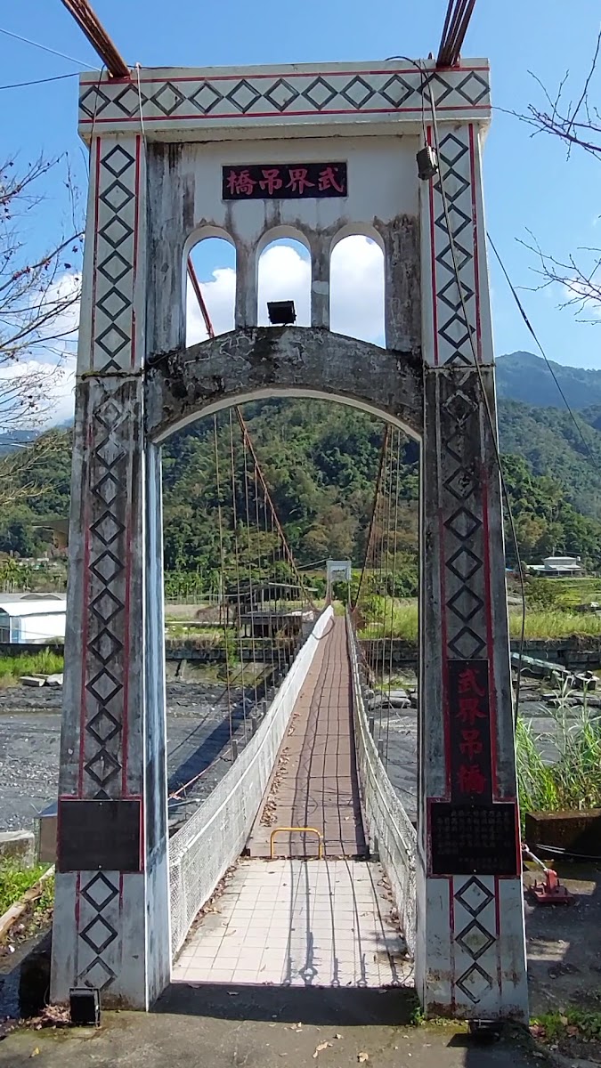 武界吊橋橋頭牌匾近拍,白色拱門塔柱上掛著「武界吊橋」紅字牌匾
