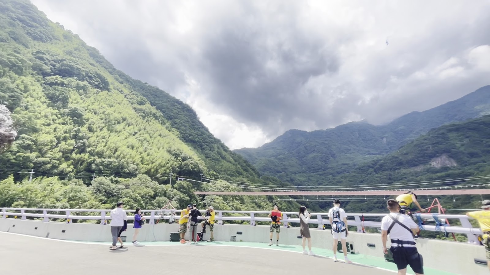 遊客在三光大橋上準備高空彈跳教練協助著裝