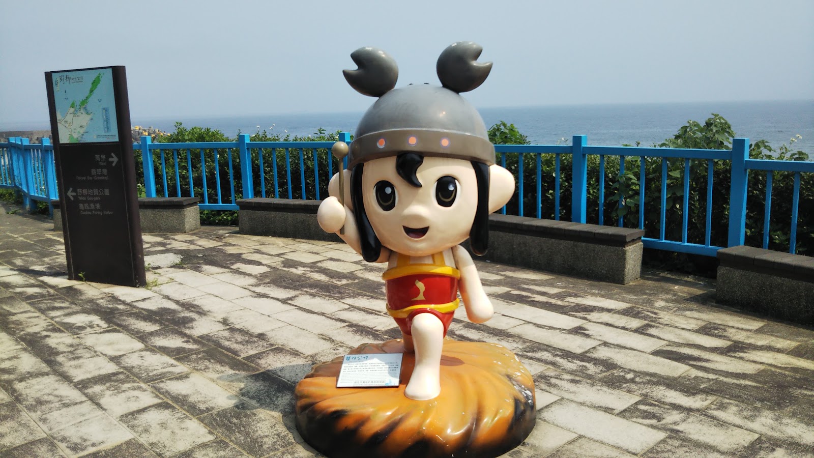 龜吼螃蟹主題公園螃蟹吉祥物雕塑,背景台灣海峽藍色欄杆