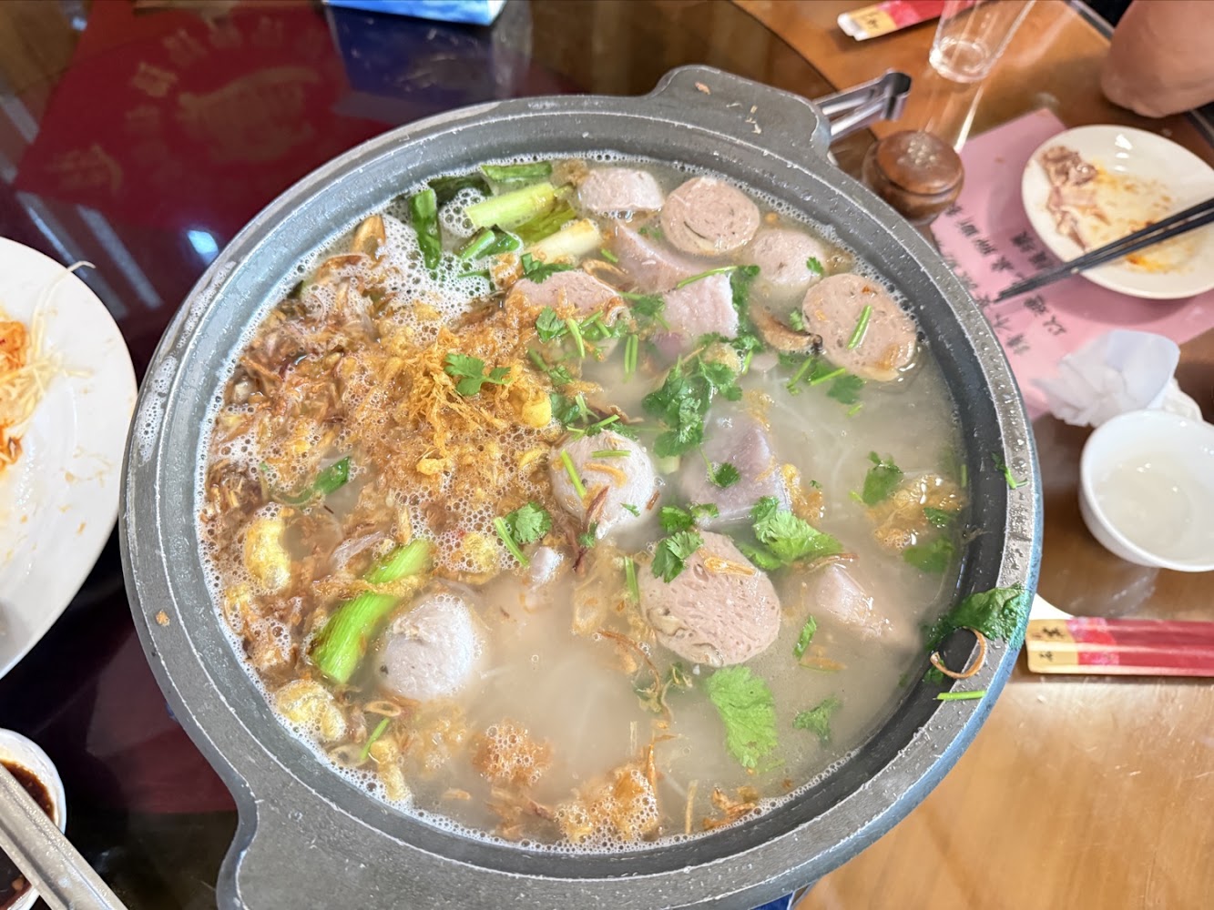 磚窯古早味懷舊餐廳火鍋料理,鍋中有丸子、蔥段與香菜等配料