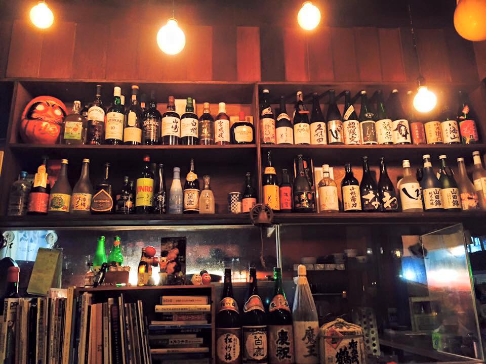 打鐵町49番地居酒屋內部木質層架擺滿日本酒威士忌酒瓶