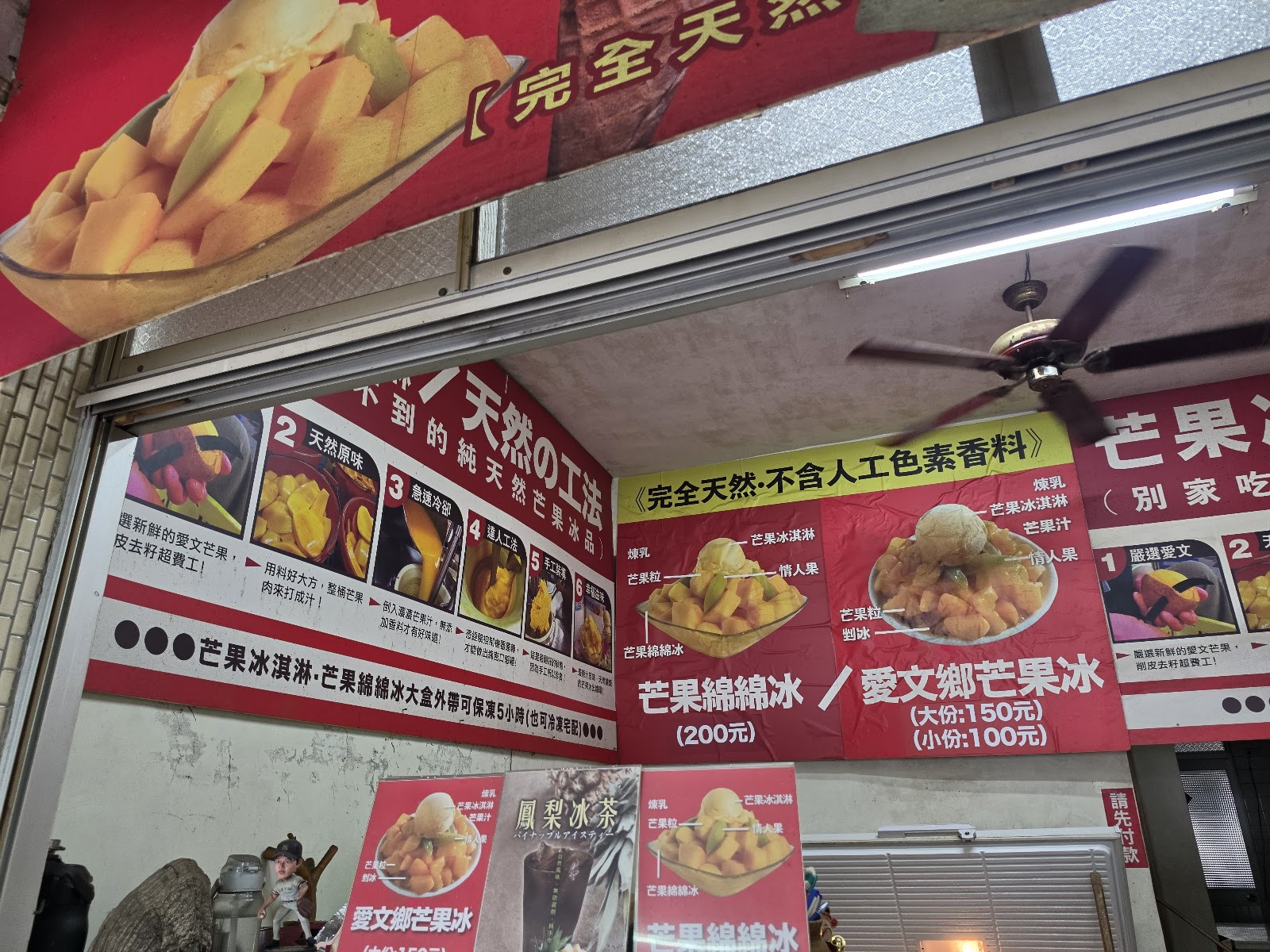 玉井批發市場旁冰品攤紅色廣告看板，顯示芒果綿綿冰200元等品項價格