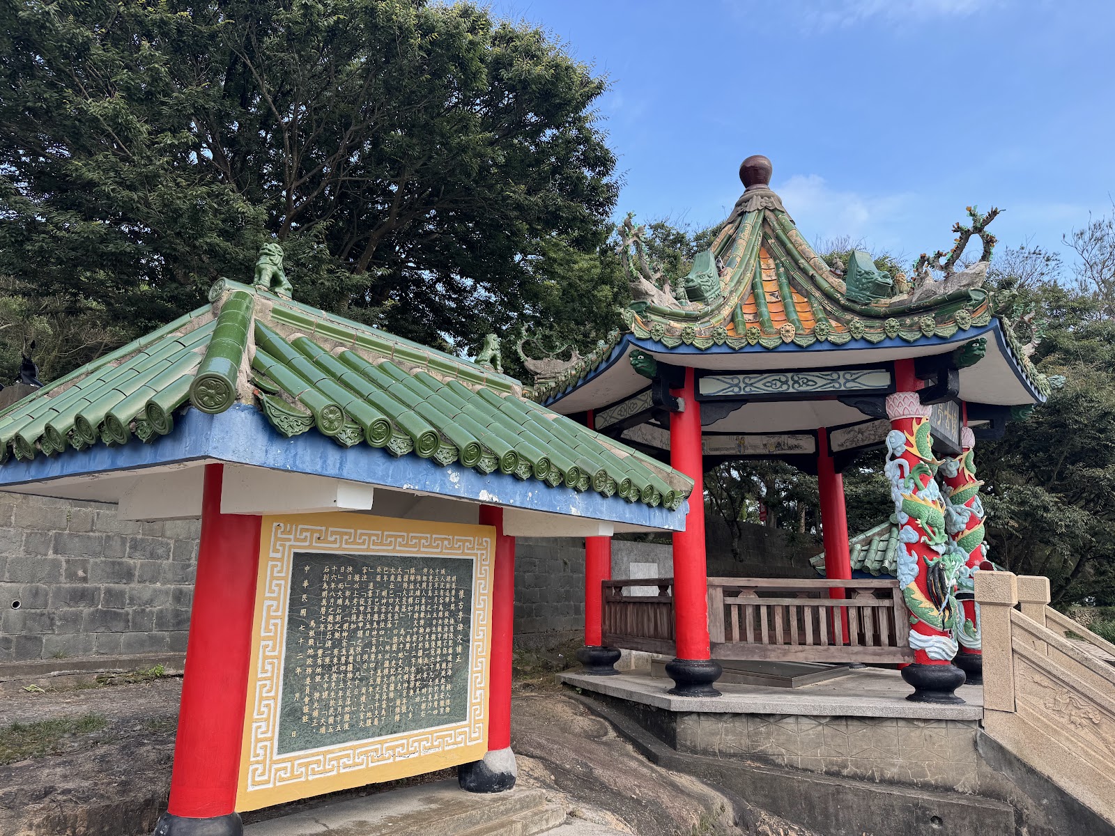 大埔石刻涼亭外觀，紅柱綠瓦與祈福紅布條