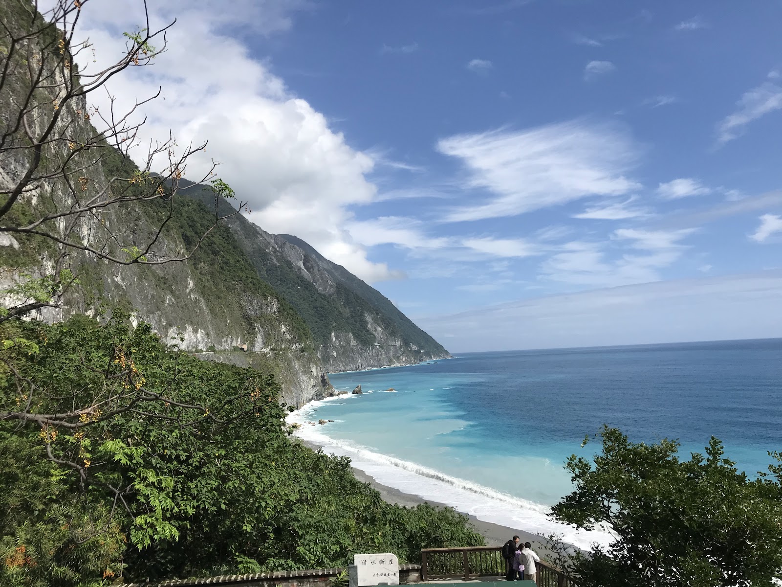 清水斷崖景觀台視角,樹木前景,藍色海灣與白色大理石峭壁