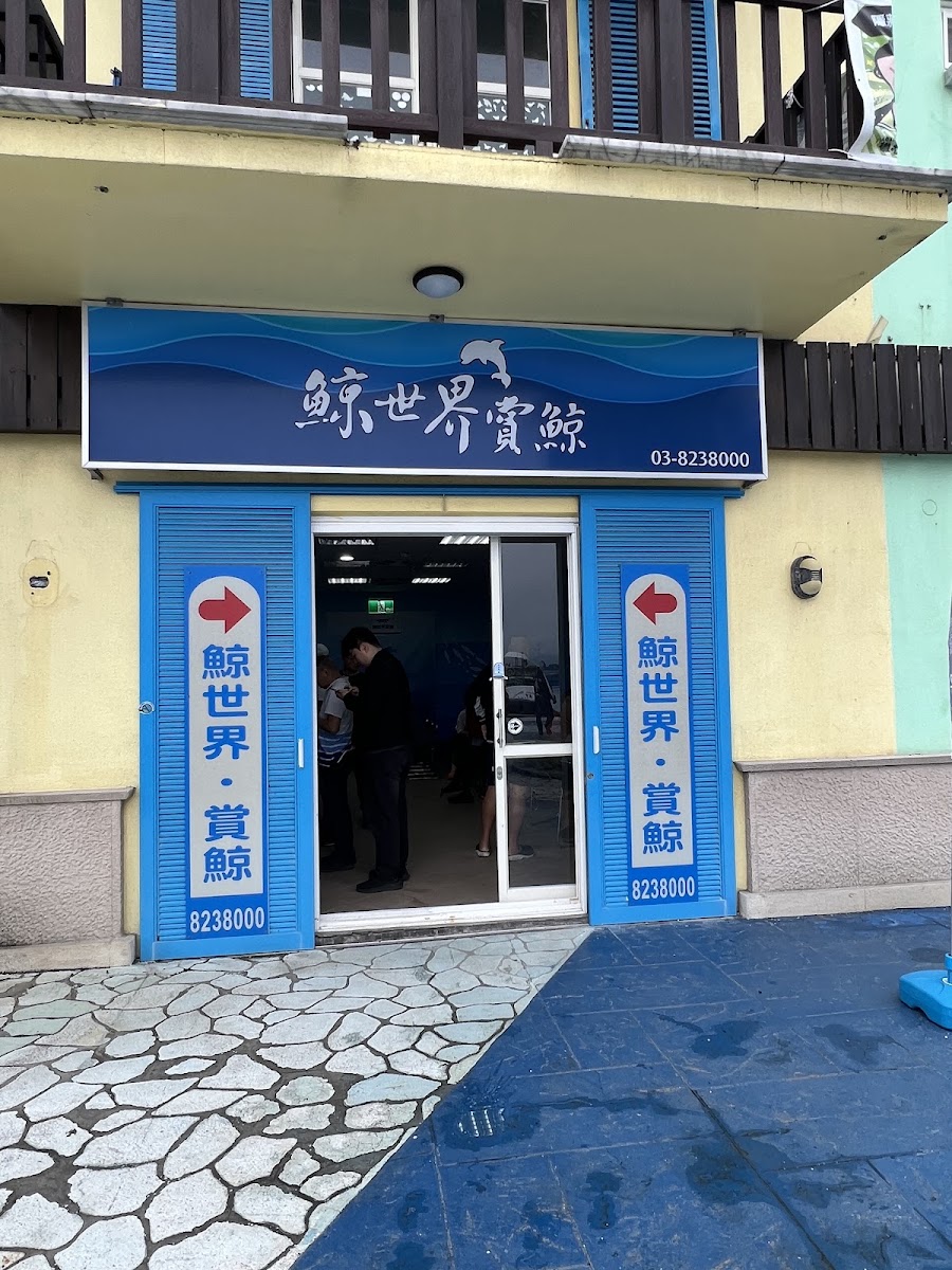 鯨世界賞鯨服務中心門口,藍色招牌醒目,兩側立牌寫有鯨世界賞鯨與電話