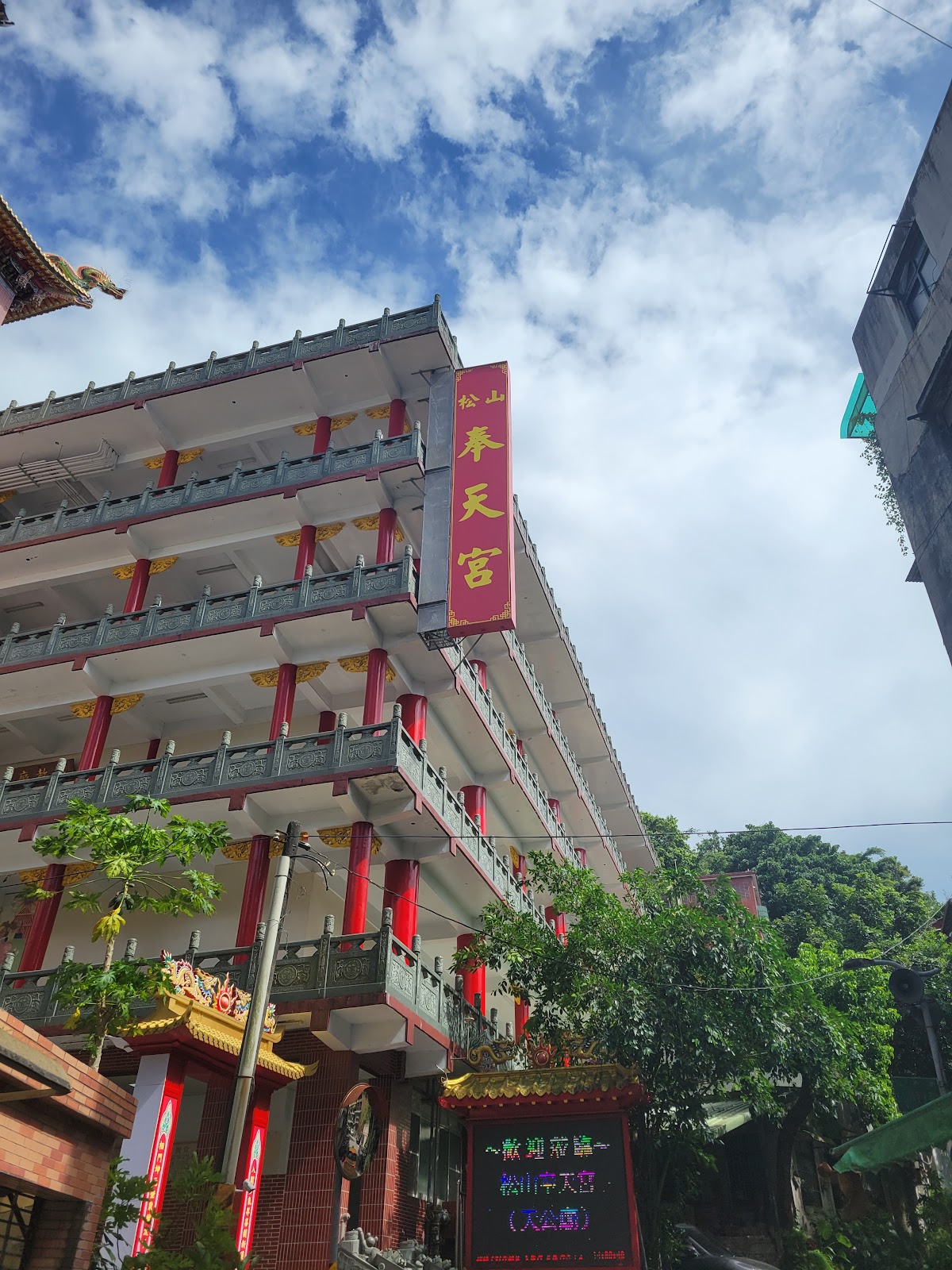 松山奉天宮多層樓廟宇建築仰角,藍天白雲背景