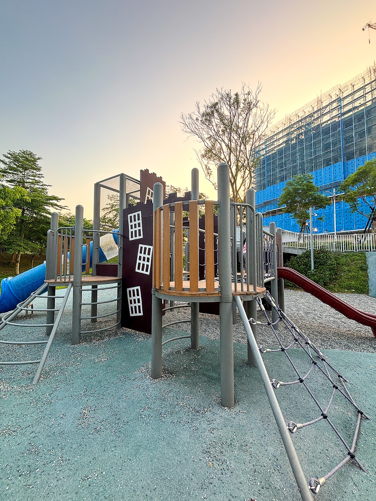 福林之丘公園地景兒童遊戲場，木質與深色系溜滑梯，夕陽映照天空