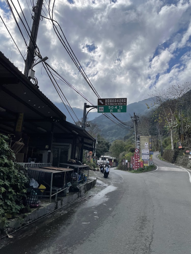 蜿蜒山路旁店鋪與青山雲景