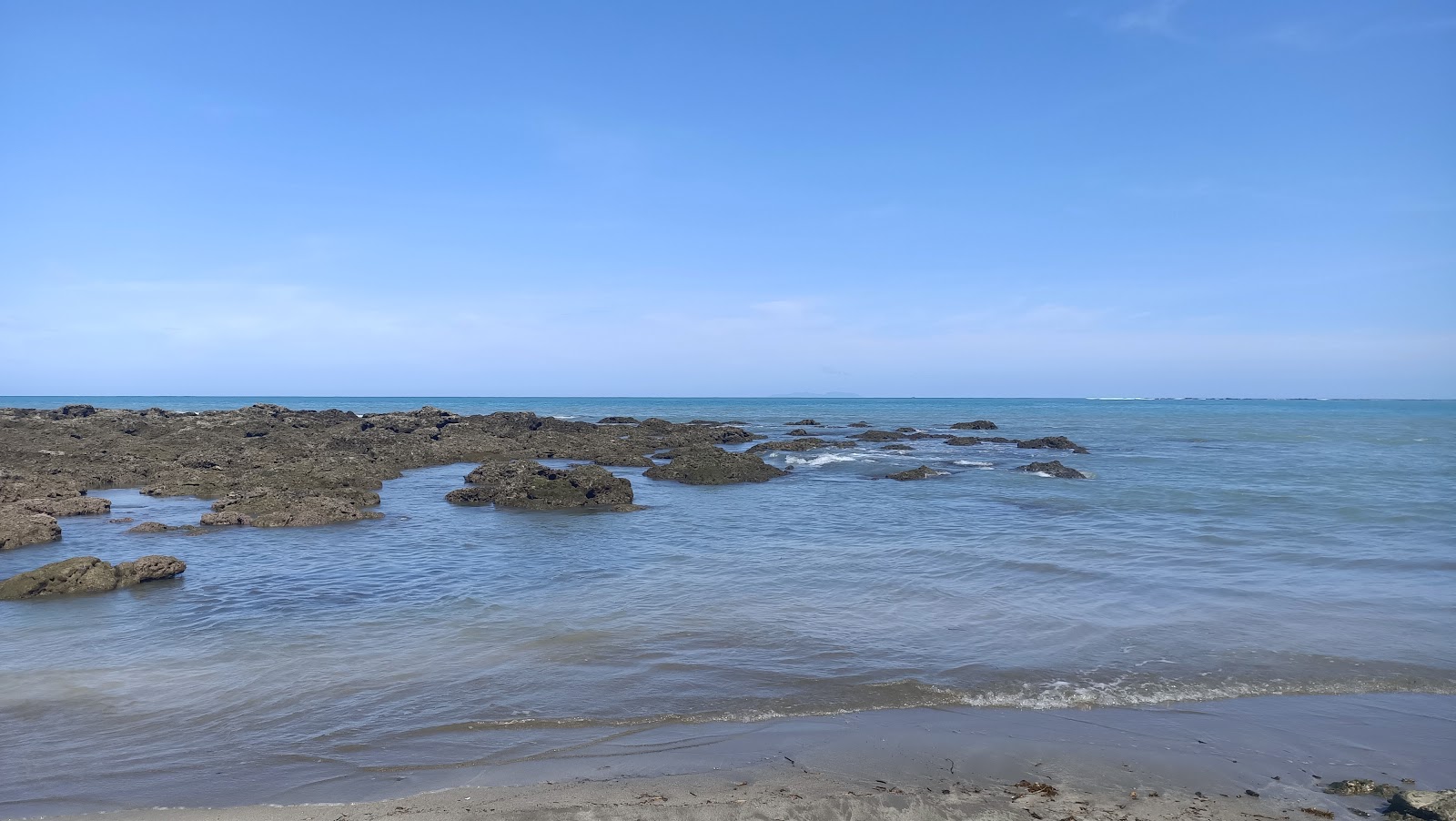 台東杉原海灣礁岩與清澈淺綠色海水，藍天白雲倒映其中