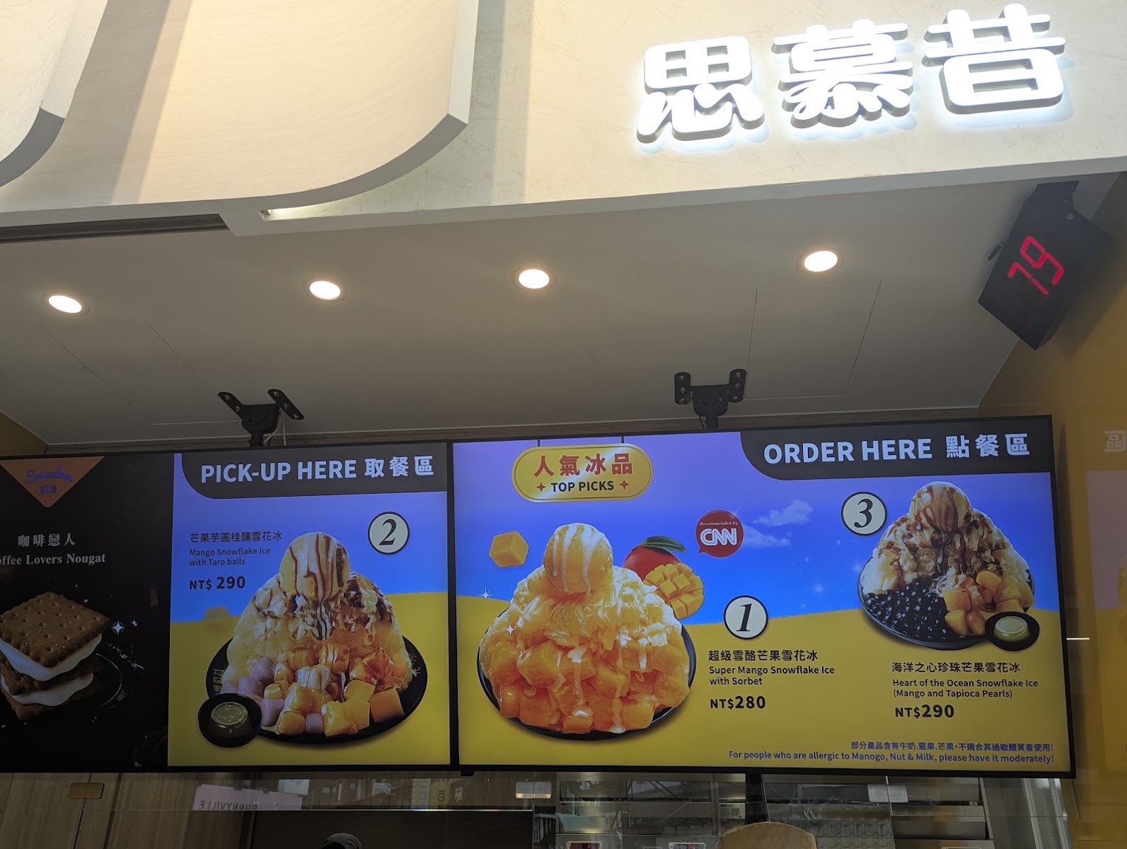 思慕昔店內點餐區,招牌燈箱與多款芒果冰品介紹看板
