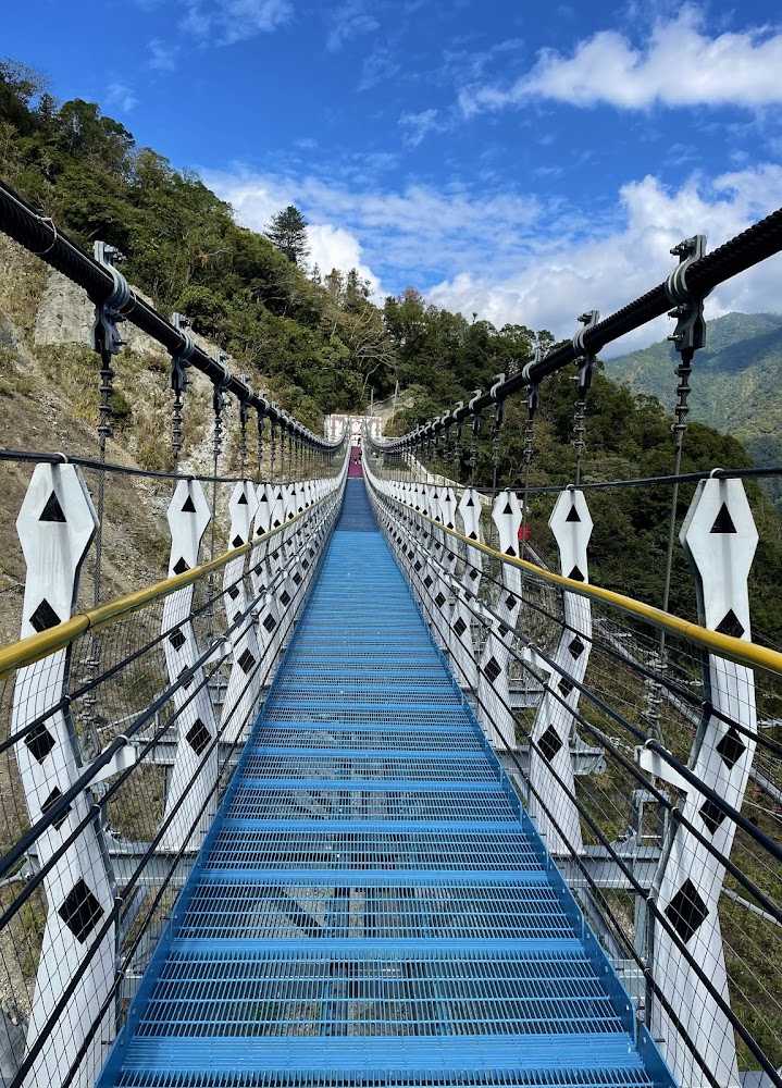 雙龍七彩吊橋藍色橋面與青山背景