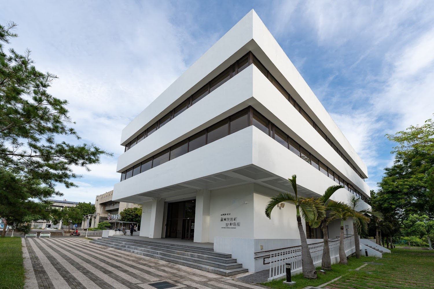 工藝設計館白色簡約建築，門前有階梯與棕櫚樹