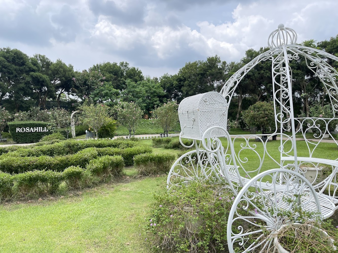 白色童話南瓜馬車造景,旁邊有大片綠色草地及修剪整齊花園