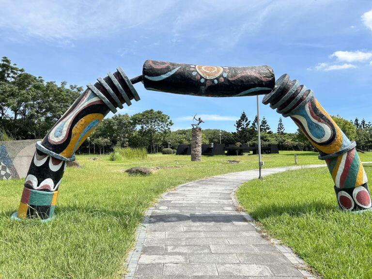 新北市立十三行博物館館外原住民圖騰彩繪拱門,石磚步道蜿蜒延伸,藍天綠草相互輝映