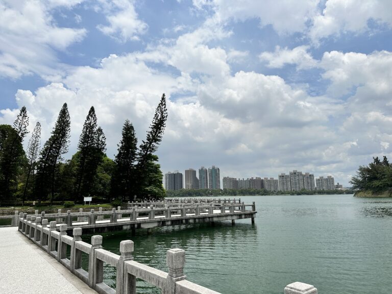 澄清湖九曲橋白色大理石欄杆，湖面碧綠倒影藍天白雲，高雄鳥松一日遊必訪景點