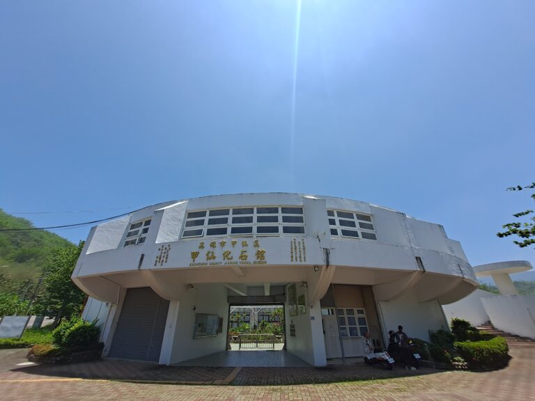 高雄甲仙化石館白色橢圓形建築正面外觀金色招牌藍天