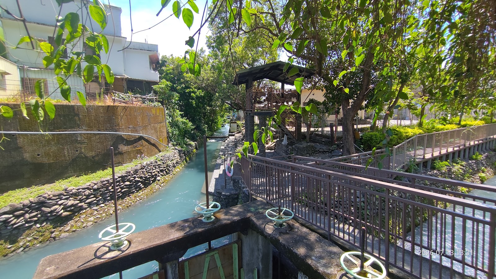 二峰圳礫石灘間湧現清澈泉水，水中魚群悠游
