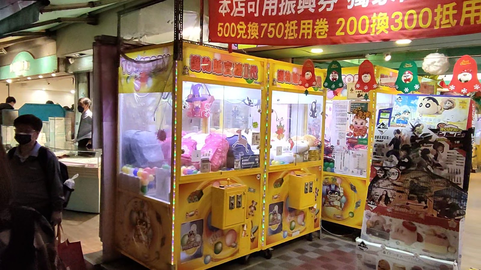 臨江街觀光夜市巷弄內的娃娃機店，色彩繽紛機台前有人駐足操作