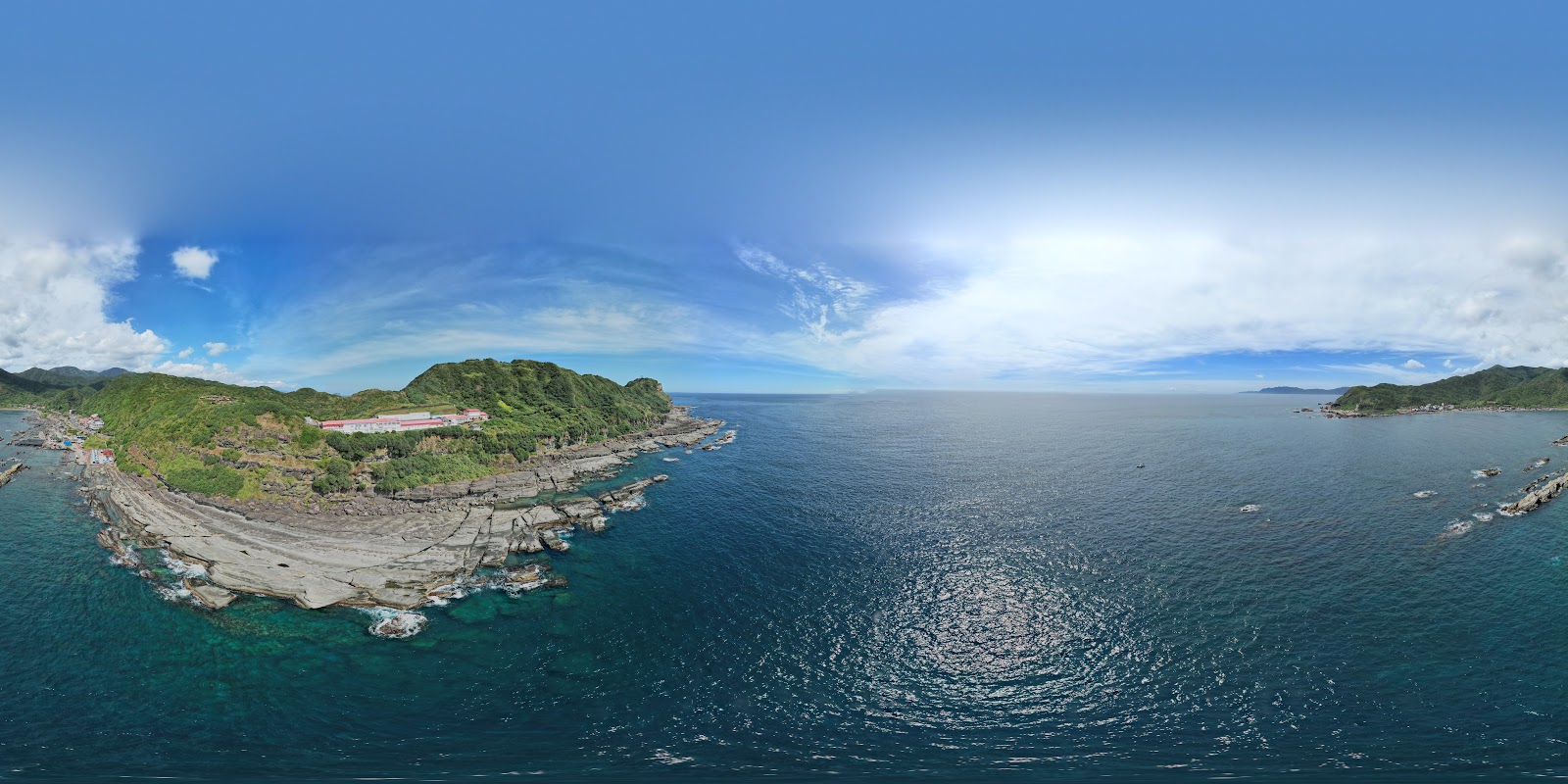 龍洞灣空拍全景，翠綠岬角礁岩海岸線與深藍海面