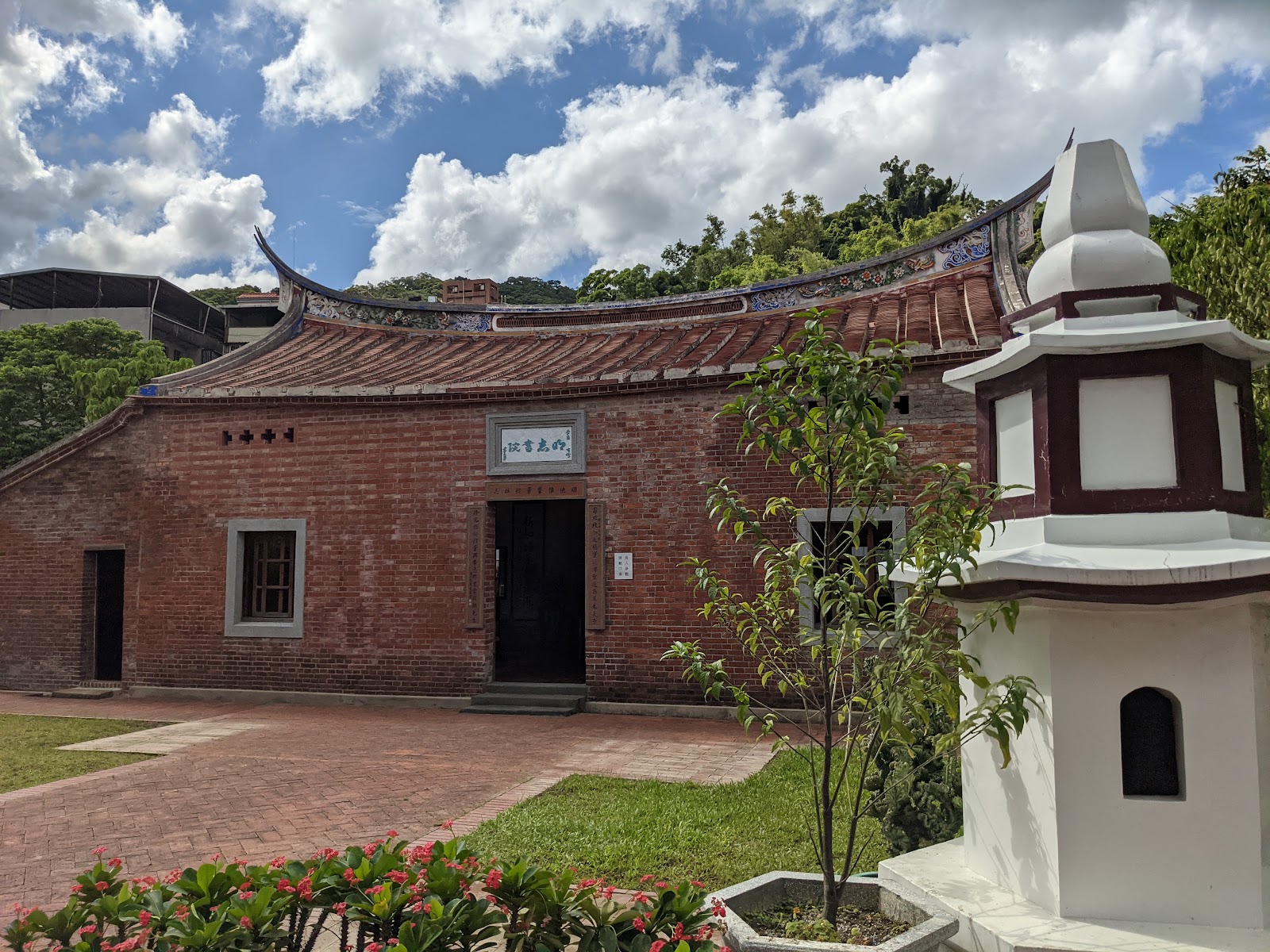 新北泰山明志書院正面,閩南式紅磚建築,庭院有石燈籠,藍天白雲背景