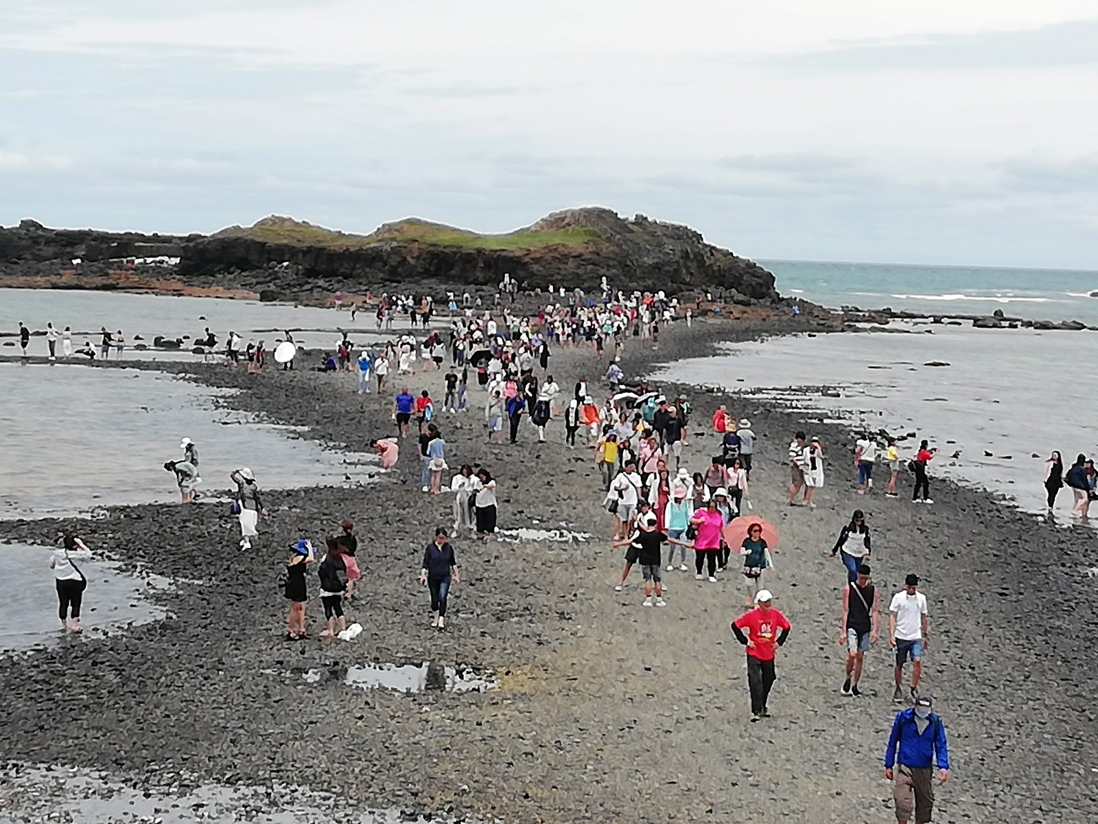 澎湖湖西鄉奎壁山摩西分海退潮礁石步道,大批遊客走向赤嶼島