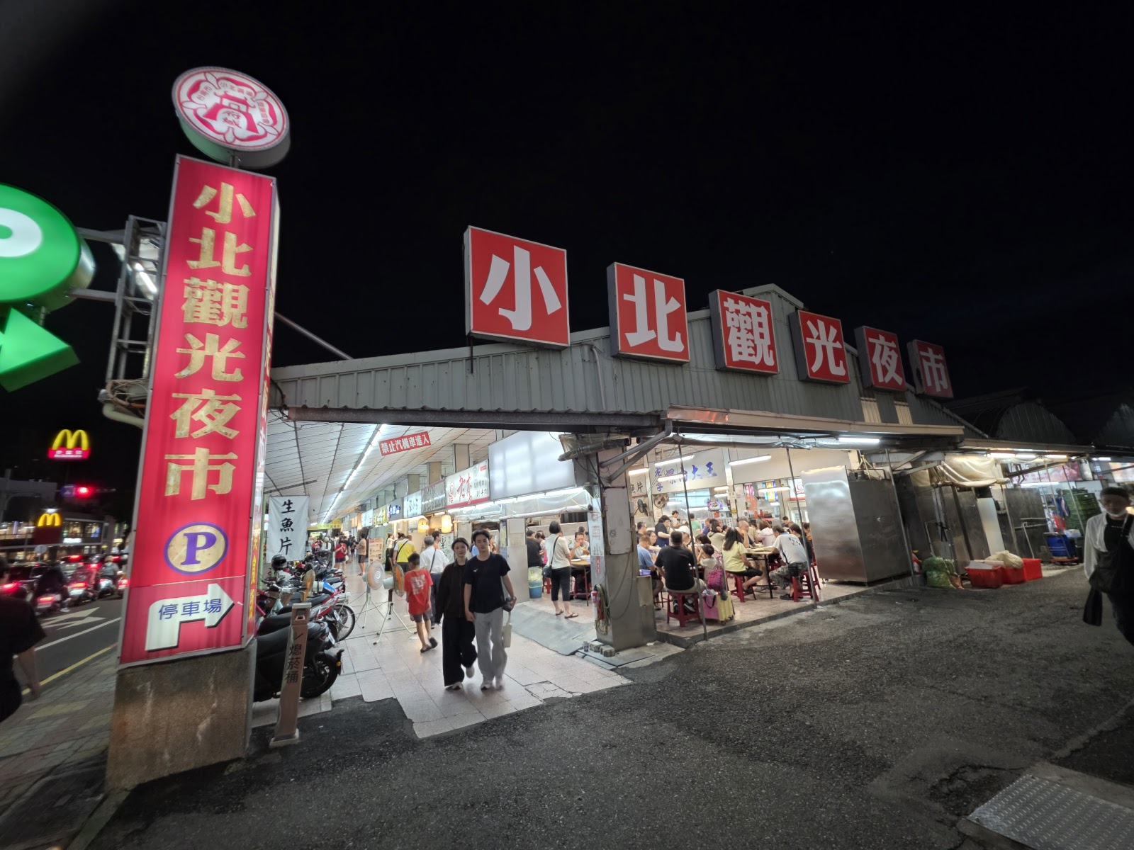 台南小北觀光夜市夜晚紅色牌樓入口，人潮往來熱鬧
