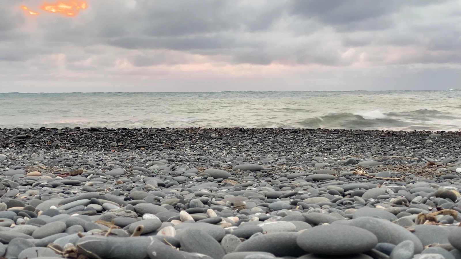 旭海漁港礫石灘近景，陰天海浪拍岸