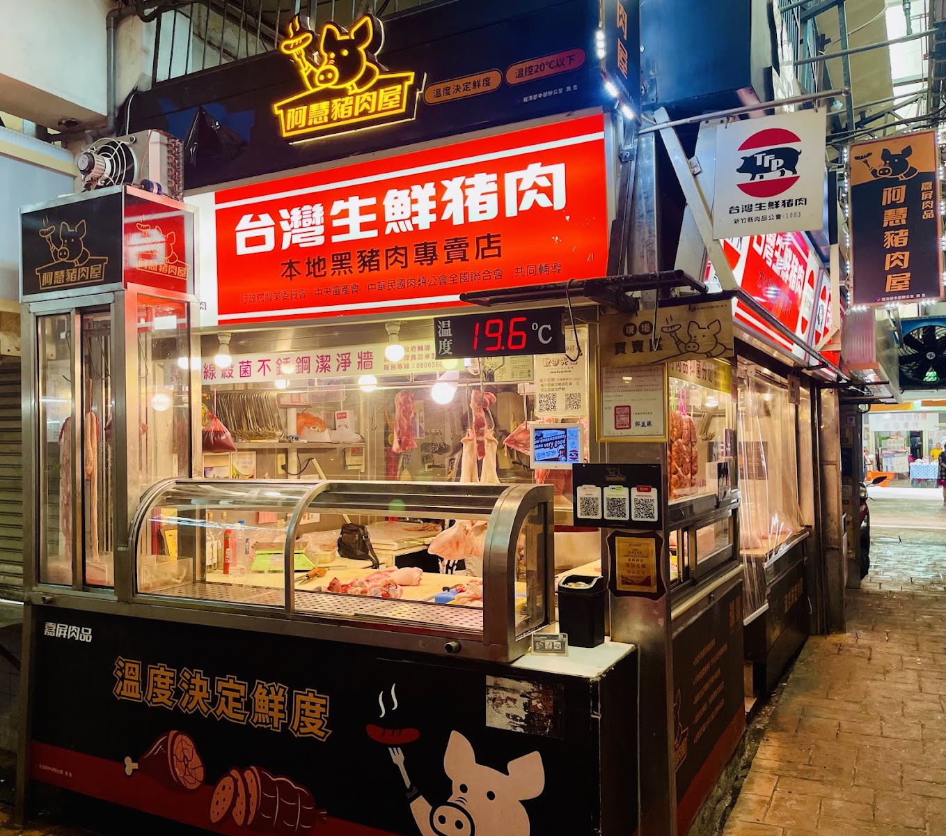 阿慧豬肉屋夜間招牌燈光明亮,展示生鮮豬肉櫃