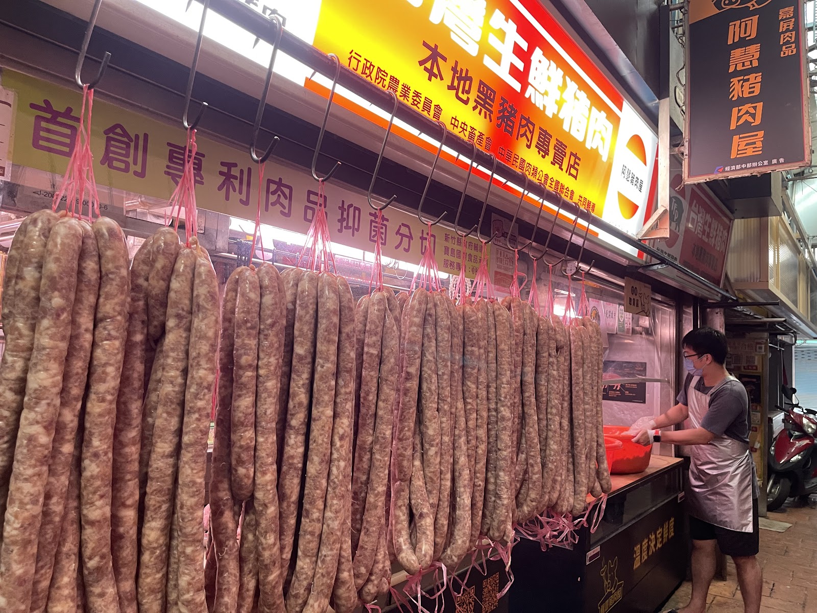 市場肉舖現場手工灌香腸,一整排香腸掛在攤架上