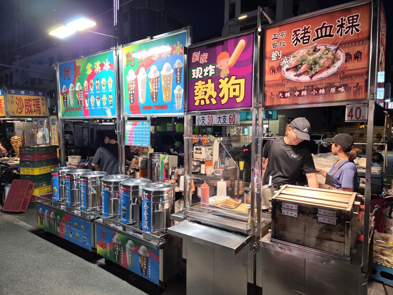 新永華夜市多個美食攤位並排,招牌色彩豐富