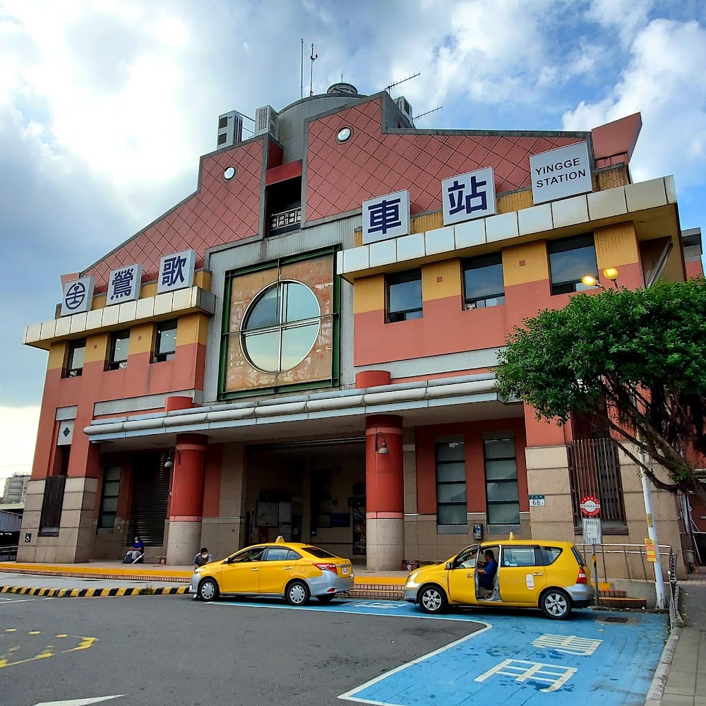 鶯歌車站外觀，前方停有計程車，招牌寫著鶯歌車站 YINGGE STATION。