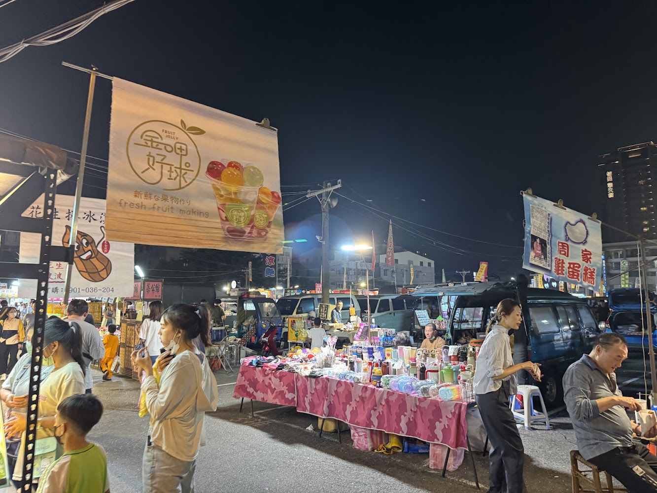 小北新成功夜市整體熱鬧場景,有飲品攤與雜貨攤