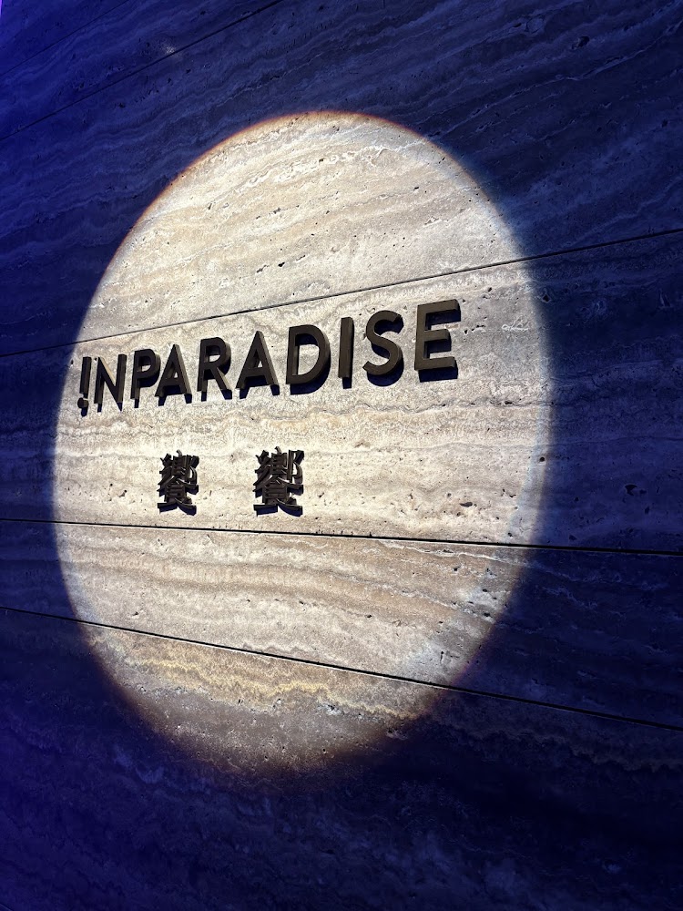 牆面上有聚光燈照亮的 !N PARADISE 樂菓 招牌