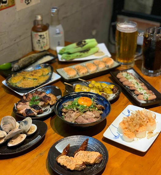 老字號居酒屋整桌日式料理豐盛多樣,有串燒、生魚片與主食