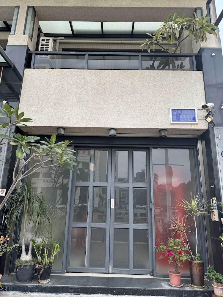 來嘉小棧外觀入口,玻璃門前擺滿植栽
