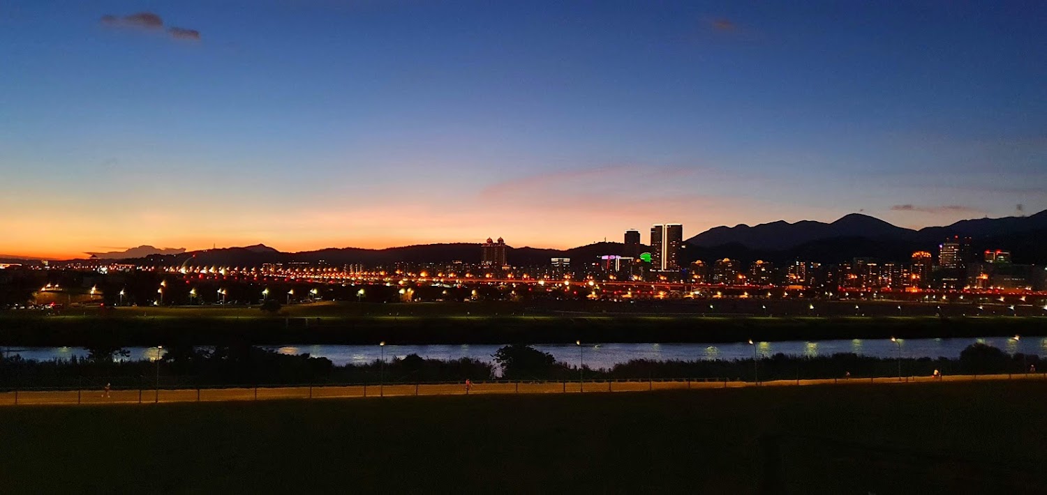 民權大橋公車站周邊黃昏夜景與河岸城市天際線
