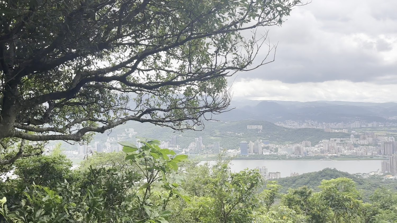 觀音山遠望河流城市與層層山巒陰天景色