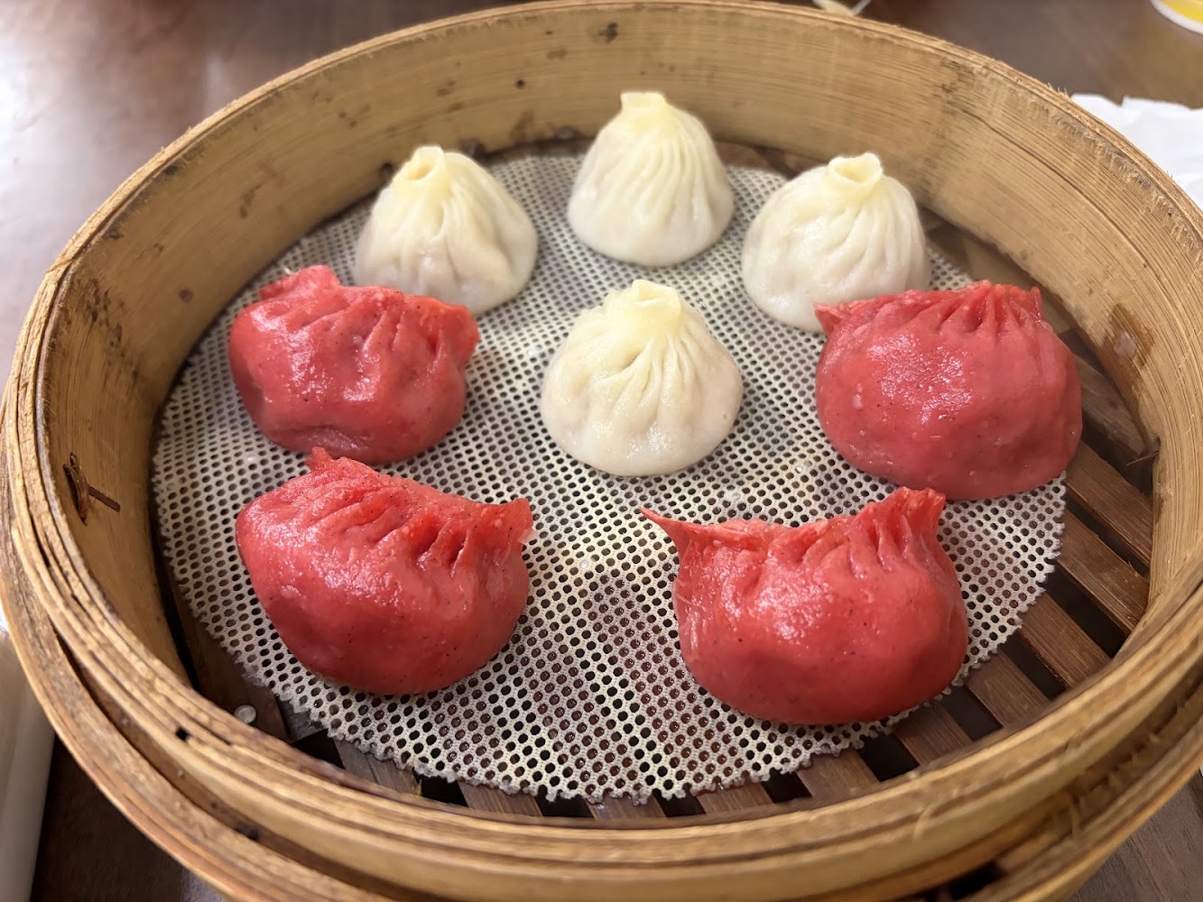 聚圓上海點心總匯蒸籠裡的彩色湯包或蒸餃