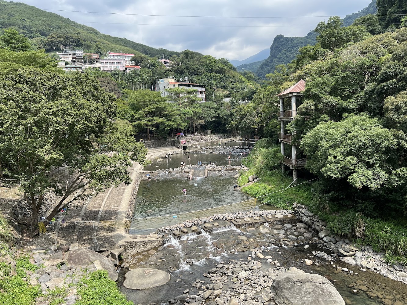 宇內溪山間戲水區全景與兩岸建築